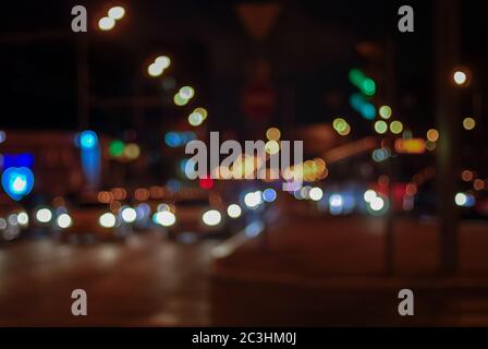 blurry traffic lights of nighttime city, dark blurred cityscape with bokeh Stock Photo