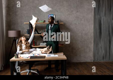 The office worker is scattering paper documents in a desire to take a break from work Stock Photo