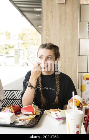 CANTERBURY, UNITED KINGDOM - Aug 29, 2019: Young teenage girl eating twix mcflurry in macdonalds happy Stock Photo