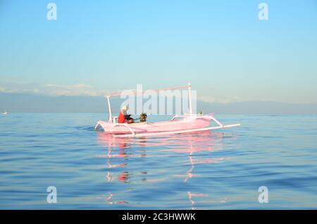 Pink colour boat on Lovina sea. It is one of Spectacular beach with Dolphin habitat and place for Watching dolphins Stock Photo