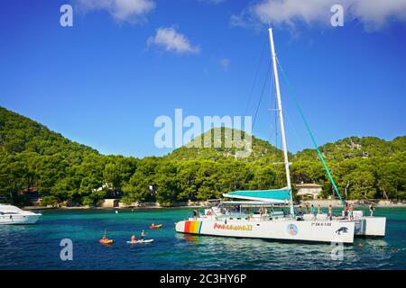 Catamaran moored in the bay at Playa de Formentor, northern Mallorca, Balearic Islands. Tourists enjoy a day trip with water sports activities. Stock Photo