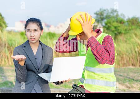 Men in hard hats and uniform with young woman. Team of architects, engineers discussing work. Stock Photo