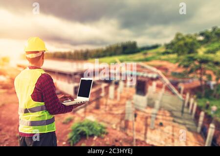 Construction Worker Planning use laptop for working and checking site construction on mountain. Stock Photo
