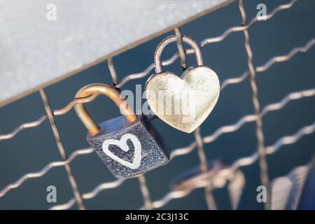 Two old rusty padlocks with heart on the bridge Stock Photo