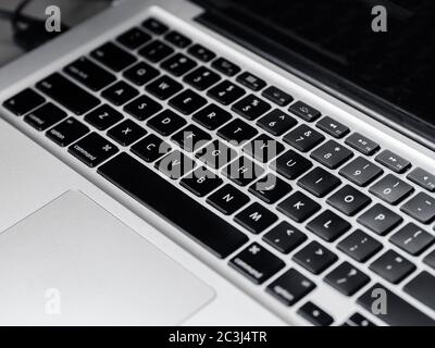 keyboard of a black notebook with gray and two cables connected in the usb port Stock Photo