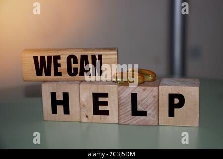 We can help - phrase on wooden blocks with letters, mutual assistance companionship concept Stock Photo