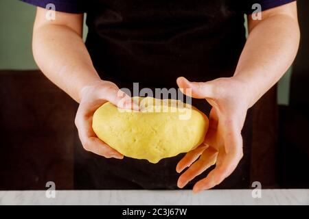 A woman holds dough for baking tasty sweet pie. Stock Photo