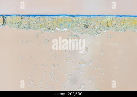 Oil bubbles in water with beige background. Stock Photo