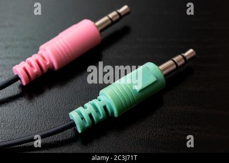 Two plugs of headphones on wooden table closeup Stock Photo