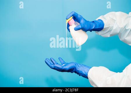 Person hand in blue glove hold soap bottle isolated on blue background. Hands hygiene virus spreading pandemic prevention Stock Photo