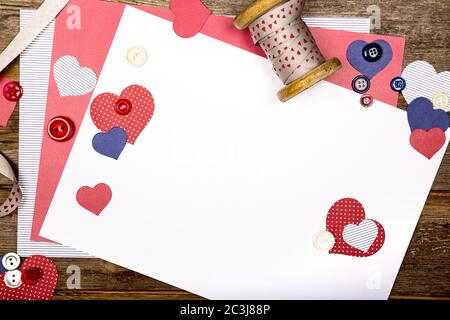 A scrapbooking themed background with cutout hearts, craft paper, ribbon and buttons. Space for your text Stock Photo