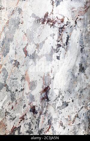 Marble effect grunge wall background with areas of peeling paint. Shades of white, grey, pink and red. Stock Photo