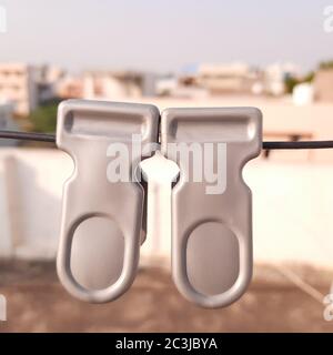 Two clips hanging on wire,over background as portrait of bulidings. Stock Photo