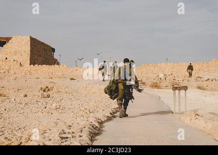 MILITARY TRAINING ZONE. Israeli soldiers walking through the territory of Masada fortification after war games. Masada, Israel: 23 October 2018. Stock Photo