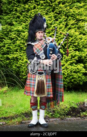 INVERARAY,  SCOTLAND - JULY 28 2015 : Scottish piper, in full national costume, plays the Bagpipes. Stock Photo