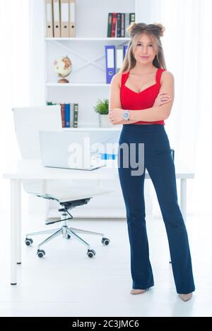 Women's office work. Secretary, realtor, manager. Beautiful blonde in a red top at the office Stock Photo