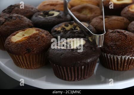 Assorted chocolate chip, marble chocolate, and apple muffins on a cake tray Stock Photo