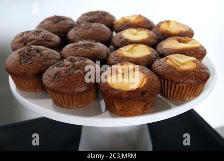 Assorted chocolate chip, marble chocolate, and apple muffins on a cake tray Stock Photo