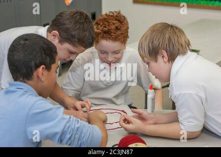 Four boys working together on a project Stock Photo