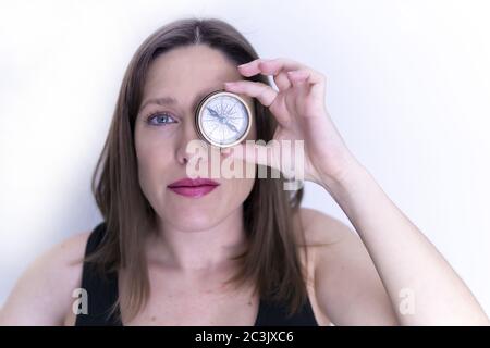 Closeup shot of a female holding a compass over the left eye Stock Photo