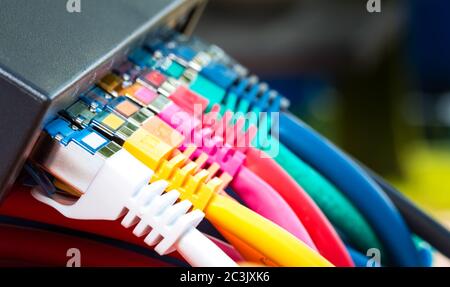 Selective focus shot of colourful network cables connected to a switch Stock Photo