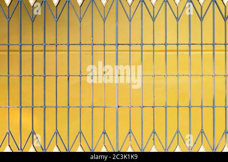 Close up iron fence With a yellow background.There is rust growing outside the building. Stock Photo