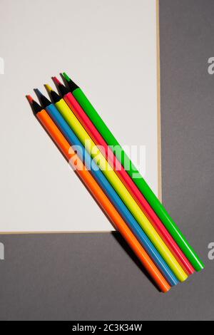 colored pencils lie on white page of  notebook Stock Photo
