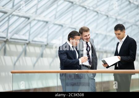 Business people having informal meeting in modern office discussing documents Stock Photo