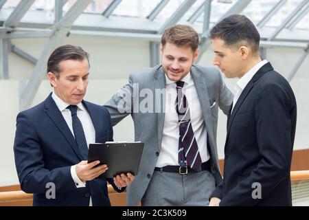 Business people having informal meeting in modern office discussing documents Stock Photo