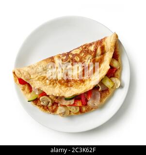 omelette stuffed with vegetables and bacon on white plate isolated on white background, top view Stock Photo