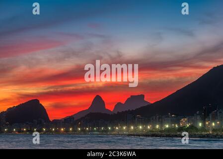 Night View of Copacabana Beach With Beautiful Red Sky Just After the Sunset, and Mountains in the Horizon, in Rio de Janeiro, Brazil Stock Photo