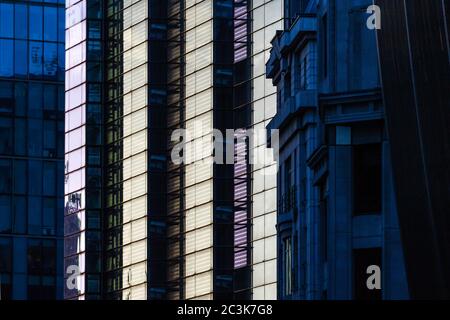 Reflected light and shadow in the City of London. The view along Bevis Marks towards Bishopsgate with Heron Tower. Stock Photo