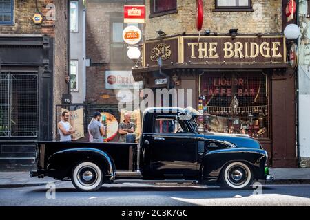 Black V8 Chevrolet lowrider pickup outside The Bridge Liquor and Caffe Bar, Kingsland Road, Shoreditch, London Stock Photo