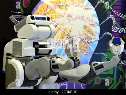 Londonderry, UK. Feb. 2017. Robot holding a Rubik's Cube with background of brain and digital numbers at Ulster University, Northern Ireland. Stock Photo