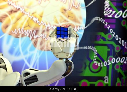 Londonderry, UK. Feb. 2017. Robot holding a Rubik's Cube with background of brain and digital numbers at Ulster University, Northern Ireland. Stock Photo