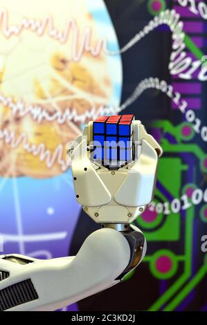 Londonderry, UK, Feb, 2017. A robot hand holding a Rubik's Cube with a background of brain and digital numbers. Stock Photo