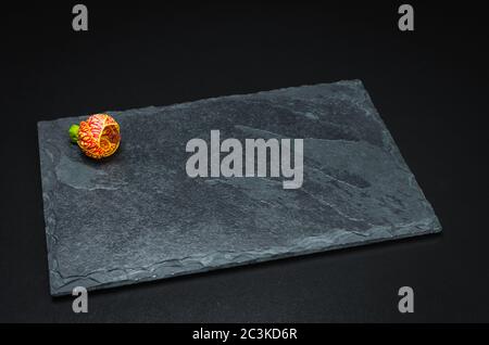 Empty slate plate on black background for use in culinary photos. Stock Photo
