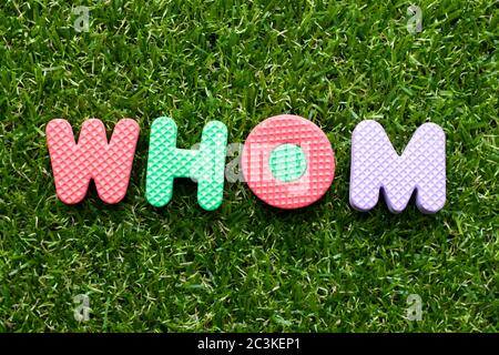 Toy foam letter in word whom on green grass background Stock Photo