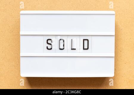 Lightbox with word sold on wood background Stock Photo