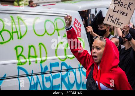 London, UK. 20th June, 2020. A woman holds up her fist during the demonstration.Black Lives Matter protests continue in The UK since the death of George Floyd at the hands of police officer in Minneapolis. Credit: SOPA Images Limited/Alamy Live News Stock Photo