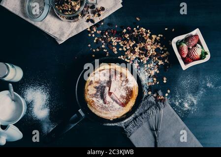 High angle shot of pancakes in frying pan and strawberries Stock Photo