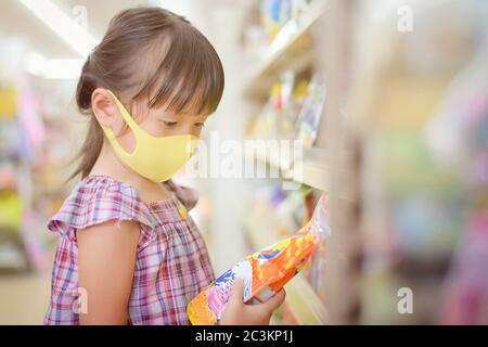 Children read labels to see the reading ingredients nutrition information and the expiration date Before buying product in the supermarket Stock Photo