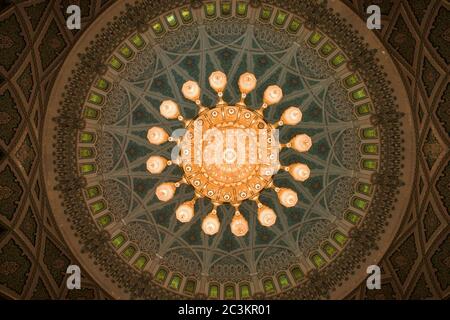 Muscat, Oman - February 28, 2016: The chandelier and inside of the dome of Sultan Qaboos Grand Mosque in Muscat, Oman. This is the largest and most de Stock Photo