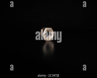 Metal nut or bolt isolated on black background. Stock Photo