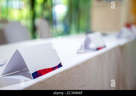 Standy triangle paper stands on the white cover table for identify the name of committee in business presentation contest event. Stock Photo