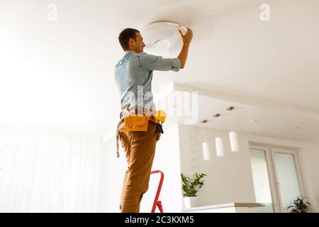 Portrait Of A Male Electrician Fixing Light On Ceiling Stock Photo - Alamy