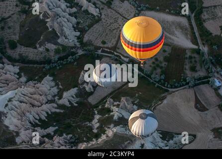 A group of hot air balloons loaded with tourists float above the incredible landscape near the town of Goreme in the Cappadocia region of Turkey. Stock Photo