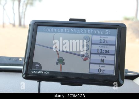 GPS unit (satnav) mounted on the windscreen of a SUV driving in the Arabian desert. Stock Photo