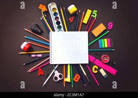 Set of different stationery, school notebook alarm clock and supplies on brown background. Back to school concept. Banner format. Top view Stock Photo