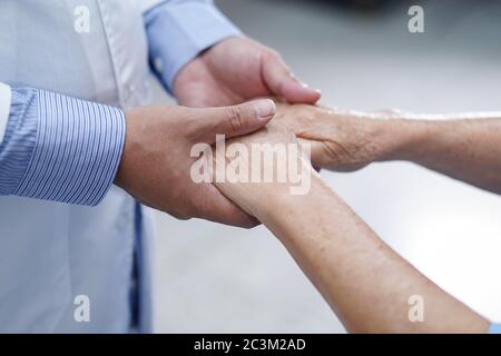 Holding Touching hands Asian senior or elderly old lady woman patient with love, care, helping, encourage and empathy at nursing hospital ward : healt Stock Photo